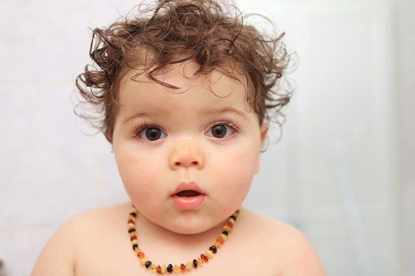 baby wearing amber teething necklace