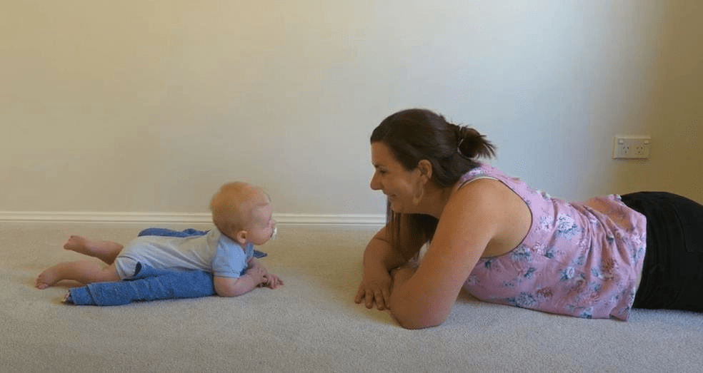 Tummy time on the floor with a towel to make tummy time easier