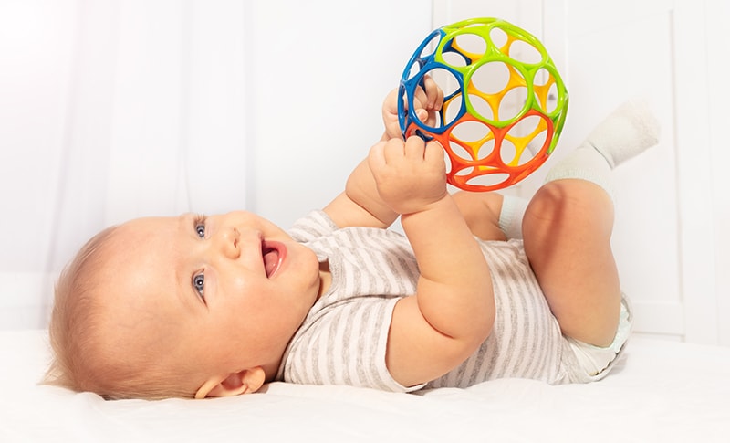 baby holding an oball