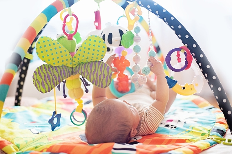 baby play gym with 3 month old baby underneath batting toys