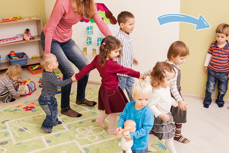 Child looking on as a group of others are playing together