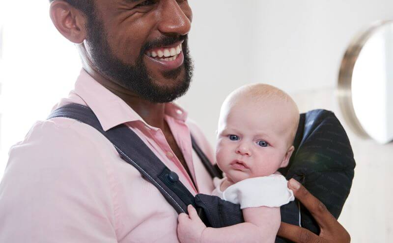 man with a baby on his chest in a baby carrier